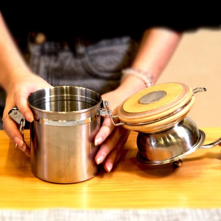 Handkurbel-Kaffeemühle aus Edelstahl, die sich gegen den Uhrzeigersinn verdickt.